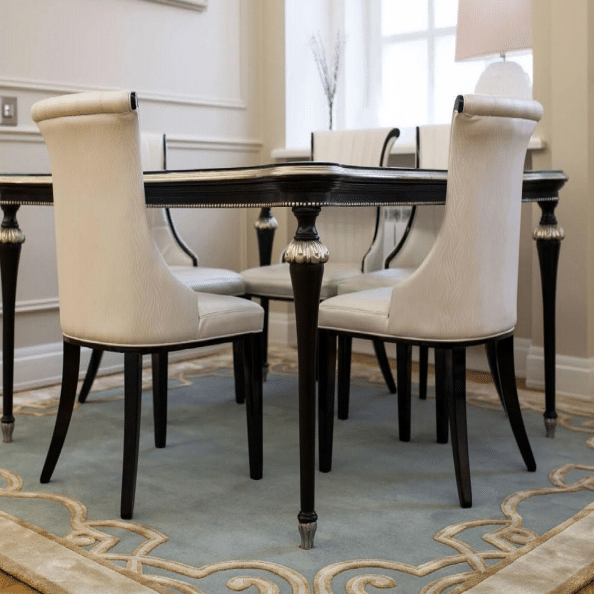 Elegant dining room with hand tufted carpet in aqua blue featuring gold ornamental borders