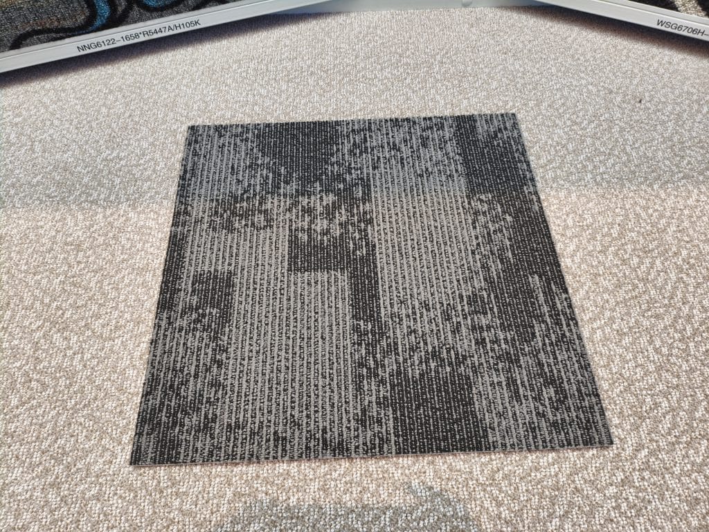 Custom carpet tile with geometric pixelated gray and black block pattern