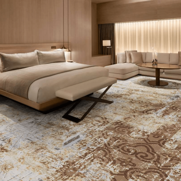 Elegant hotel bedroom with beige and brown Wilton carpet featuring ornate baroque-style motifs