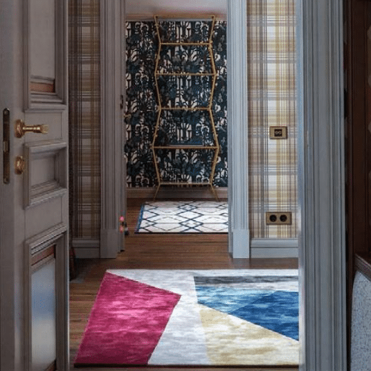Hallway featuring color block carpet with red, blue, yellow, and white geometric shapes