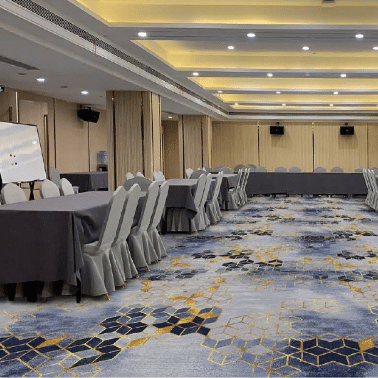Spacious conference hall with gray, blue, and gold geometric printed carpet