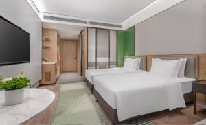 Alt Text: Professional high-pressure steam extraction cleaning a patterned hotel room carpet to remove deep-seated odors and bacteria.