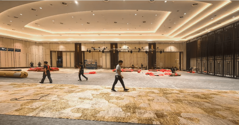 6,500 square meters of custom blue and gold Axminster wool carpet with abstract water ripple patterns in the Hyatt Macau ballroom.