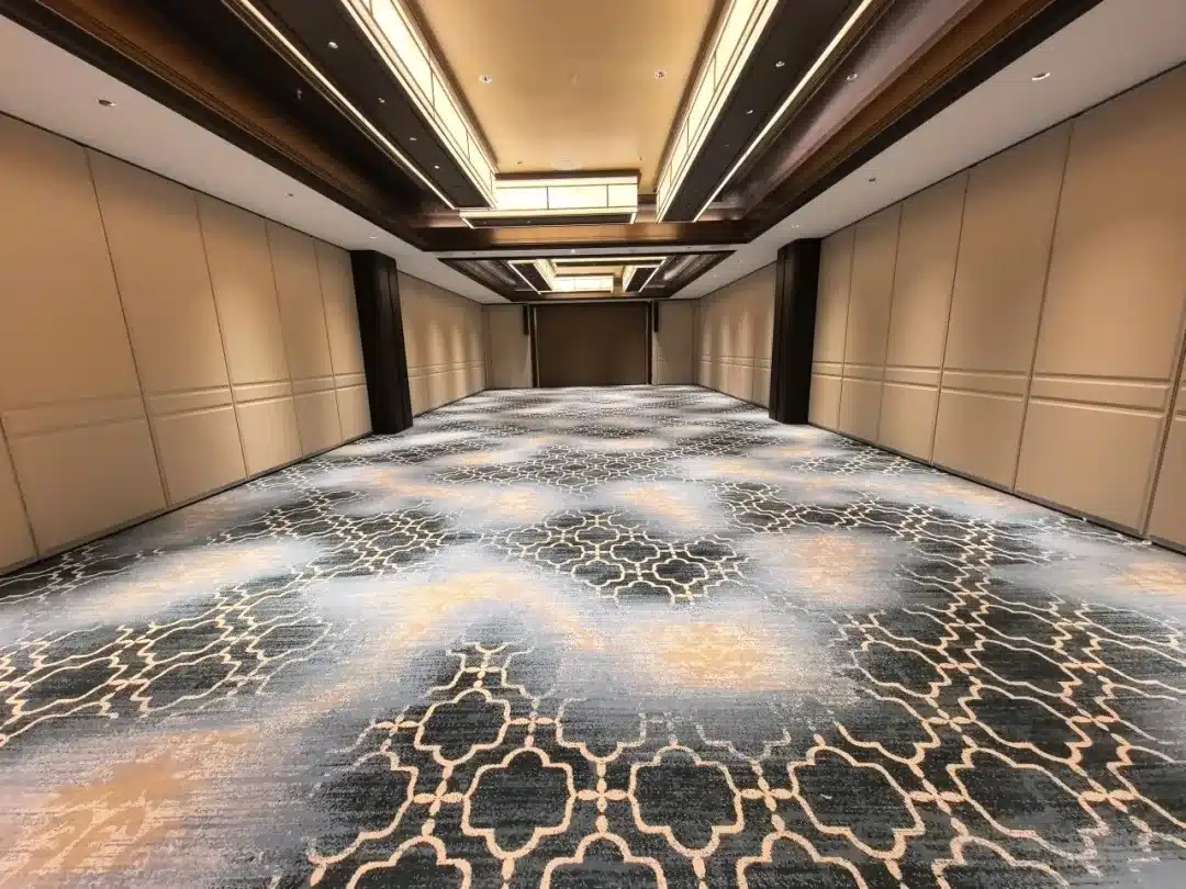 Detailed view of high-traffic 80/20 wool-nylon hotel carpet showing flame-retardant fibers and bespoke floral wave patterns for a luxury hospitality project.