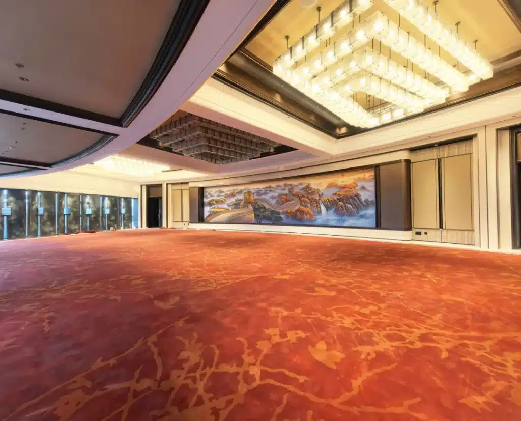 Detailed view of high-traffic 80/20 wool-nylon hotel carpet showing flame-retardant fibers and bespoke floral wave patterns for a luxury hospitality project.
