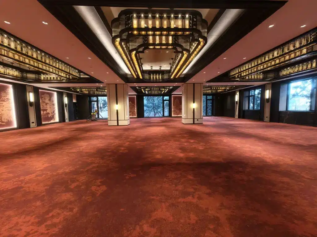 Detailed view of high-traffic 80/20 wool-nylon hotel carpet showing flame-retardant fibers and bespoke floral wave patterns for a luxury hospitality project.