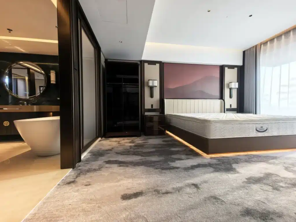 Detailed view of high-traffic 80/20 wool-nylon hotel carpet showing flame-retardant fibers and bespoke floral wave patterns for a luxury hospitality project.