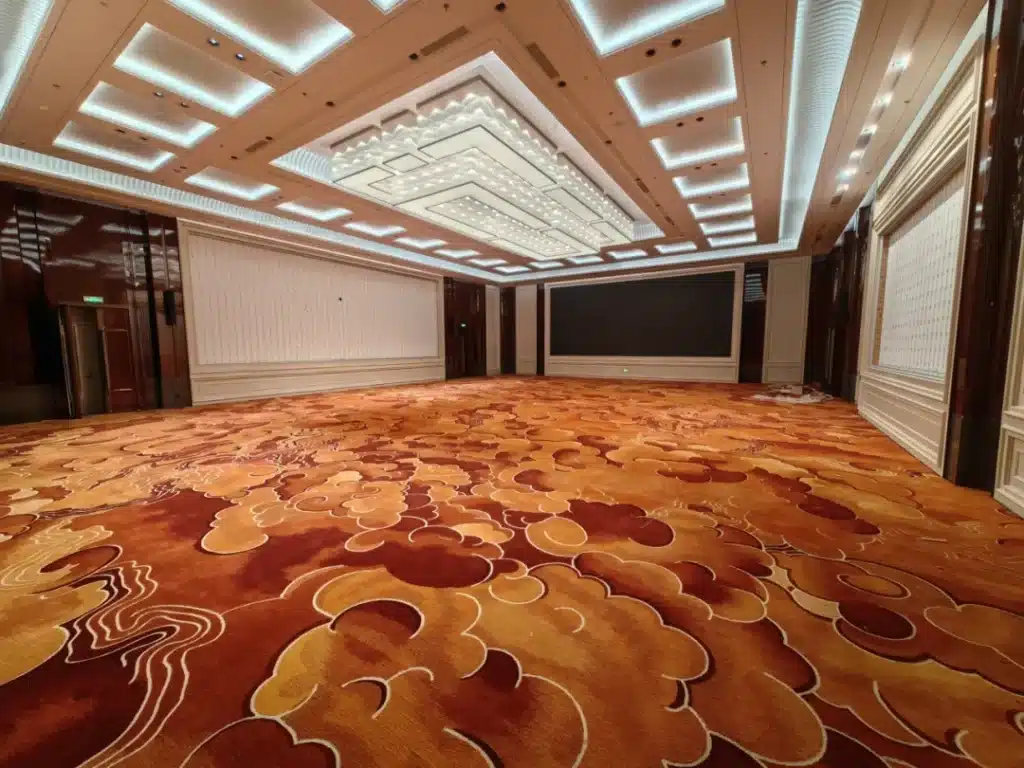 Detailed view of high-traffic 80/20 wool-nylon hotel carpet showing flame-retardant fibers and bespoke floral wave patterns for a luxury hospitality project.