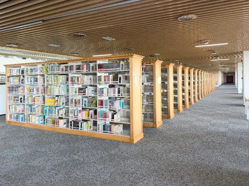 QIANQIAO eco-friendly carpet tiles in deep gray installed across the spacious reading room floor at the Jinan Vocational College library.